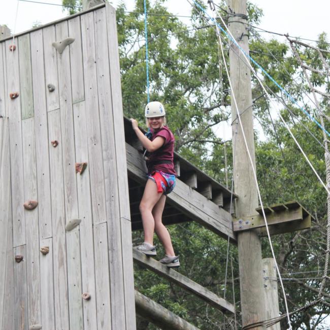 girl on ropes course at camp